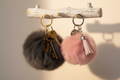 Porte-clés pompons gris grand et rose petit avec frange - suspendus sur crochet en bois